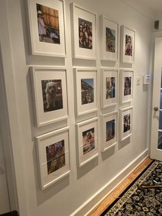 a wall with many pictures on it and a rug in front of the door way