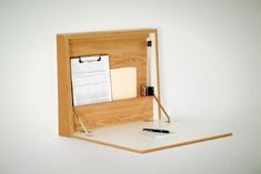 an office desk with a pen, notepad and clipboard in a wooden box