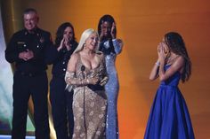 lady in gold dress standing on stage with other people