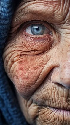 an old woman with wrinkles on her face and blue eyes looking at the camera