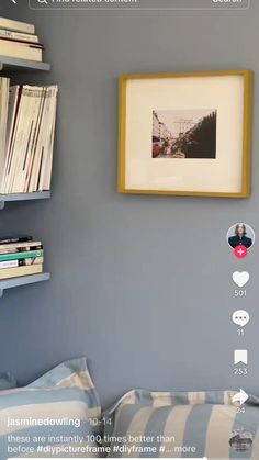 a bedroom with blue walls and pictures hanging on the wall, along with bookshelves