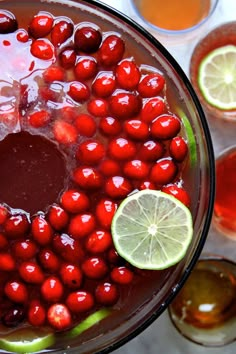 a bowl filled with cherries and lime slices