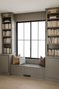 a window seat with bookshelves in front of it