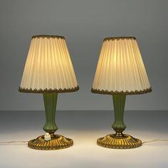 two green lamps sitting next to each other on a table