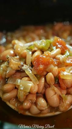 a spoon filled with beans and onions