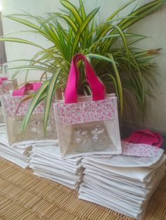 several bags are stacked on top of each other near a potted plant and some napkins