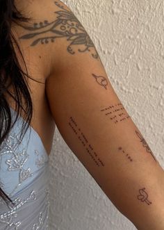 a woman with a tattoo on her arm that has words written in cursive writing