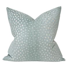 a light blue and white pillow with dots on the front, sitting on a white background