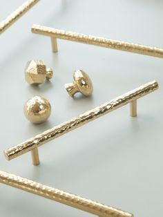 three pairs of gold ear studs and one pair of earrings on a white surface