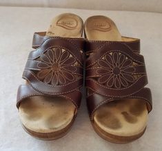 a pair of brown sandals sitting on top of a white sheet