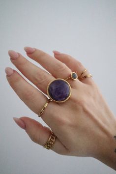 A large statement crystal ring made of gold stainless steel with an adjustable band.  The ring features a round polished amethyst crystal of 2cm in diameter. Minimalist Gold Amethyst Ring, Adjustable Stainless Steel Midi Rings, Minimalist Gold Amethyst Ring For Gift, Gold Minimalist Amethyst Ring For Gift, Adjustable Tarnish Resistant Crystal Ring As Gift, Adjustable Tarnish Resistant Crystal Ring Gift, Gold Crystal Ring With Natural Stones, Gold Midi Rings With Gemstone, Gold Round Crystal Ring With Natural Stones