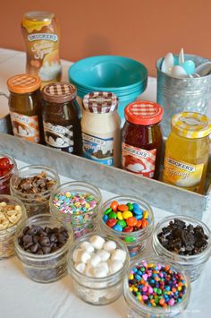 a tray filled with lots of different types of candy and toppings on top of a table