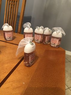 six bottles of liquid sitting on top of a wooden table