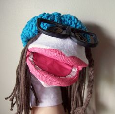 a doll wearing a knitted hat and eyeglasses with dreadlocks on it's head