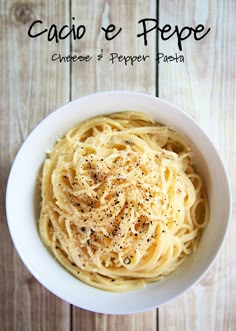 a white bowl filled with pasta on top of a wooden table