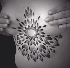 a woman's stomach with a black and white flower tattoo on it