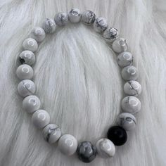 White Marble Beads With A Dark Stone Colored Bead Stretch Bracelet Handmade Casual White Crystal Bracelet, White Faceted Beads Crystal Bracelet, White Crystal Bracelet With Faceted Beads, Everyday White Crystal Bracelet With Faceted Beads, White Faceted Crystal Bracelet, Casual White Hand-strung Crystal Bracelet, White Minimalist Crystal Bracelet With Round Beads, Casual White Stretch Bracelet With Gemstone Beads, Elegant White Stretch Bracelet With Black Beads