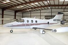 an airplane is parked in a hanger with other planes around the perimeter and on the floor