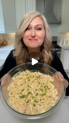 a woman holding a large bowl filled with food