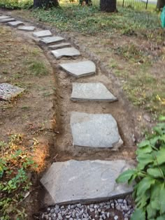 a stone path in the middle of a yard