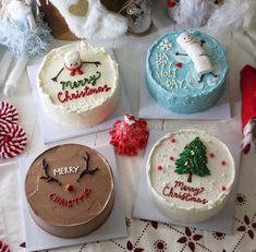 four decorated christmas cakes sitting on top of a table