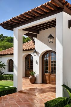 the front entrance to a house with two large doors and an attached walkway leading into it