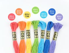 six skeins of multicolored thread in different sizes and colors on white background