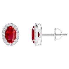 This luxurious pair of ruby halo stud earrings is designed in platinum. The oval red gems are surrounded by a dazzling halo of round diamonds. Ruby is the Birthstone for July and traditional gift for 15th & 40th wedding anniversaries. Features 1.2 ctw Ruby and 0.19 ctw Diamond. Crafted in Platinum. We offer high-quality gemstone jewelry in a variety of stunning designs. The exceptional craftsmanship ensures that every piece lasts for generations. All gemstones are sourced directly from mines and Red Gems, 40th Wedding Anniversary, Halo Stud Earrings, Halo Earrings Studs, E 40, Diamond Halo, Halo Diamond, Jewelry Earrings Studs, Round Diamonds