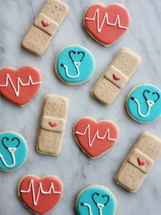 decorated cookies in the shape of medical instruments and hearts on a marble surface with white icing