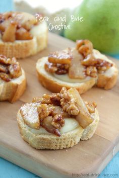 mini pecan and pine crostini on a cutting board next to an apple