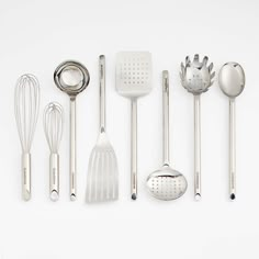 kitchen utensils lined up on a white surface