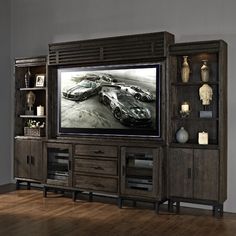 an entertainment center with a large television on top of it