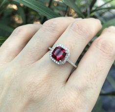 "A stunning princess-shape faceted 1ct lab-made Ruby accented with a halo of petite cubic zirconia is a lovely engagement/promise/anniversary ring handcrafted in sterling silver. Wrapped in a box ready for gift-giving. (r-egt-126-lab ruby) Ring Info -------------------------- Lab Ruby 6mm, 1ct Lab Ruby with Halo measure 9mm Shank width 1.5mm Stone height 7mm ----> Please note there is an additional fee, if we have to size the ring again so please make sure you know your ring size. ---> Don Cushion Cut Ruby Jewelry Gift, Cushion Cut Ruby Jewelry As Gift, Cushion Cut Ruby Jewelry For Gift, Asscher Cut Ruby Fine Jewelry, Red Diamond Ring In Asscher Cut, Red Diamond Ring With Asscher Cut, Dazzling Ruby Ring With Accent Stones For Gift, Dazzling Ruby Ring With Accent Stones As Gift, Ruby Jewelry With Asscher Cut For Anniversary