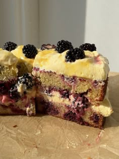 there is a cake that has been cut in half with blueberries on top and blackberries on the bottom