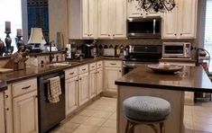 a kitchen with white cabinets and stainless steel appliances, along with a breakfast nook