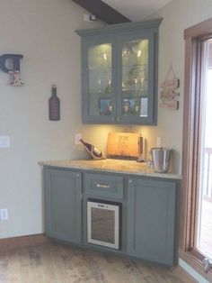 a kitchen with gray cabinets and wooden floors