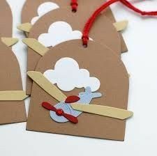 four brown paper tags with red string attached to them and an airplane on the front