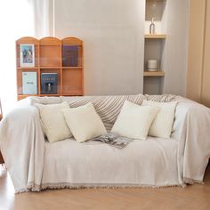 a living room with a white couch covered in pillows