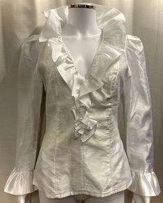 "This is an authentic 1980s ruffle blouse in white Organza. Details in include a deep V neck with large frilled collar, frilled cuffs and a fitted waist. It is fully lined and has a long zip at the back for opening. Size and fit: This top is fitted and there is no stretch to the fabric. The waist measures 28\" and the chest is approximately 36\". It would best fit a UK size 8-10. Condition: This top is in good vintage condition however, there is a pale yellowish stain around the waist area, as shown in the last photo." 80s Ruffle Blouse, Victorian Ruffle Blouse, Frill Collar Blouse, Formal V-neck Blouse With Ruffles, Elegant V-neck Ruffled Blouse, Wedding V-neck Blouse With Ruffles, Elegant Blouse With Ruffled Collar And Ruffle Hem, Elegant Ruffled V-neck Blouse, Elegant V-neck Ruffle Blouse