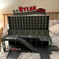 a toy car track set on top of a bed