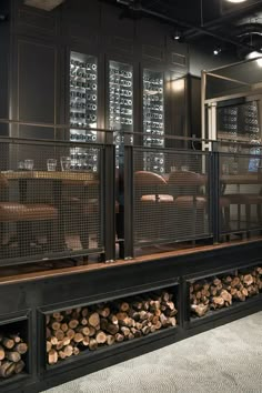 a room with lots of wood stacked on top of each other in front of glass doors