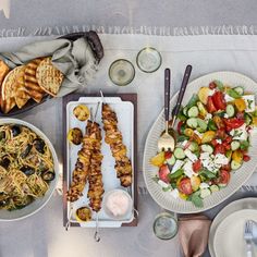 a table topped with plates and bowls filled with food