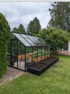 a small greenhouse in the middle of a yard