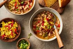 three bowls of bean soup with bread on the side