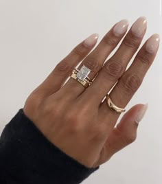 a woman's hand with two gold rings on it and one diamond in the middle