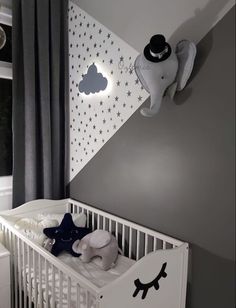 a baby's room decorated in white and grey with stars on the wall, crib