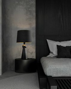 a black and white bedroom with a bed, night stand and lamp in the corner