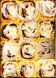 a pan filled with cinnamon rolls covered in icing