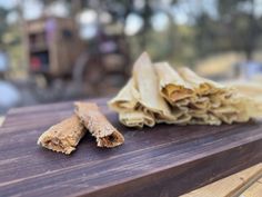 two pieces of food sitting on top of a wooden table next to a piece of wood