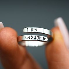 two silver rings with i am enough written on them